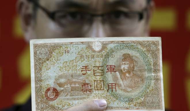 Wang Jinsi, president of the ‘Chinese Federation of Demanding Compensation from Japan Limited’ holds a ‘Hundred-dollar Japanese military bill’ at a press conference in Wan Chai, Hong Kong. File photo