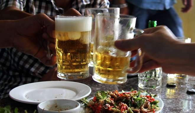 Men in Vietnam drink beer to go with their meals in a restaurant in Hanoi. Photo: AFP