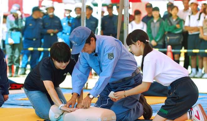 Japanese Prime Minister Shinzo Abe performs first aid on a training model as he participates in an earlier annual disaster drill in Saitama on September 1. Photo: AFP
