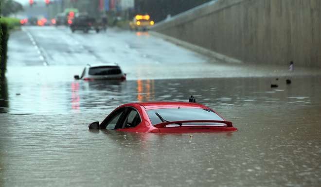 A car is swamped by flood water under an overpass in Haikou, capital of south China's Hainan Province. Photo: Xinhua