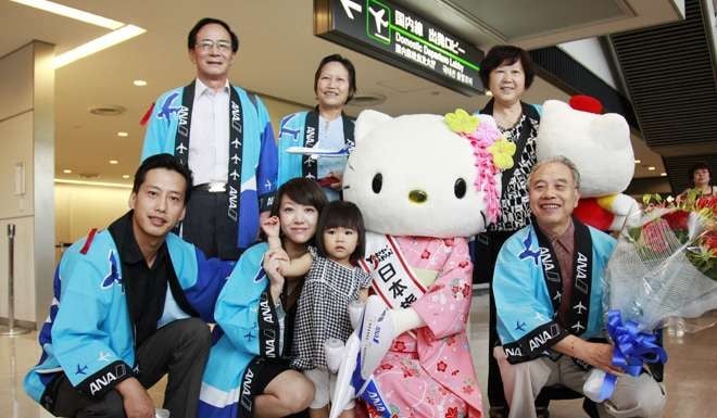 Chinese tourists pose with Japanese tourism mascot Hello Kitty. Photo: Xinhua