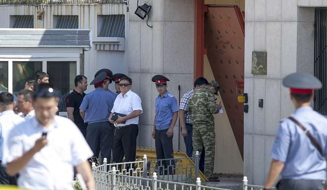 Police officers examine the broken gates of the Chinese Embassy in Bishkek in Kyrgyzstan, following the suicide bombing. Photo: AP