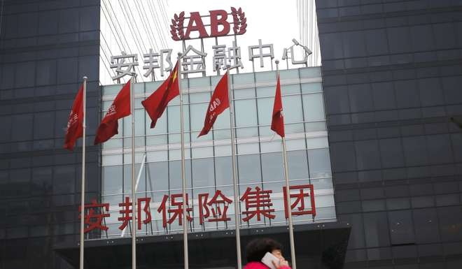 A woman walks past the Anbang Insurance Group's building in Beijing. Photo: AP