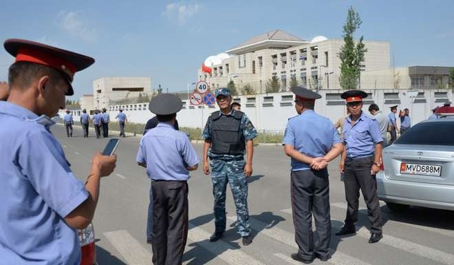 Kyrgyz police officers gather outside the Chinese embassy in Bishkek following the suicide bombing on August 30. Photo: AFP
