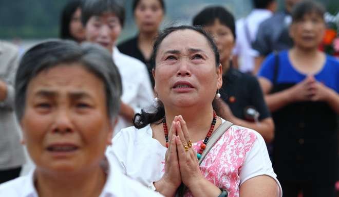 Women weep while saying prayers in front of the statue of the late Mao Zedong on Friday in Shaoshan. Photo: Simon Song
