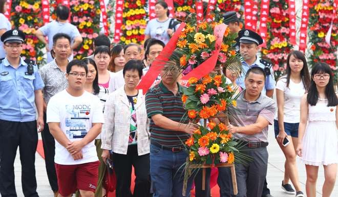 People carry a wreath up to the statue of Mao Zedong in Shaoshan on Friday to mark the 40th anniversary of the death of the leader. Photo: Simon Song