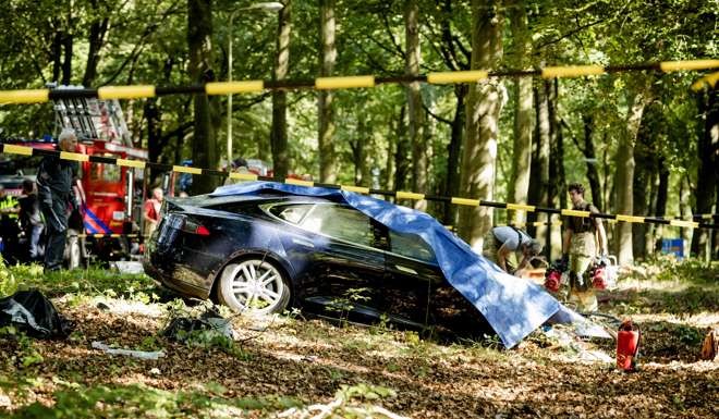Rescue workers proceed with caution around the spot where a Tesla slammed into a tree in Baarn, the Netherlands, on September 7. Photo: AFP