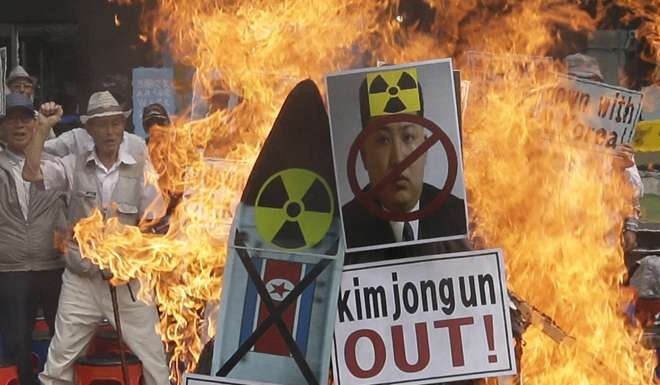 Protestors in Seoul deface an image of North Korean leader Kim Jong-un in Seoul on Saturday. Photo: AP