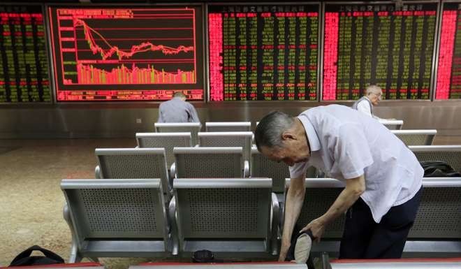 Investors in front of computer screens showing stock market movements at a securities brokerage house in Beijing on the day of the Brexi vote. Chinese mainland markets traded lower, with the Shanghai composite down 0.95 per cent and the Shenzhen composite down 0.10 per cent after the results from the UK referendum. Photo: EPA