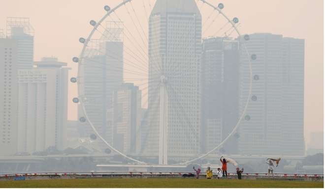 People take photos near the Singapore Flyer observatory wheel shrouded by haze on August 26. Photo: Reuters