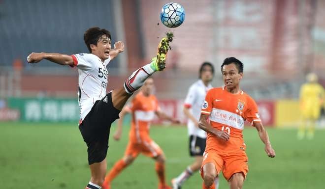 FC Seoul defender Kwak Tae-hwi vies for the ball against a Shangdong Luneng player. Photo: Xinhua