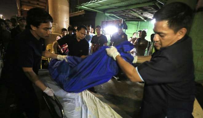Philippine funeral parlour workers collect the body of an alleged drug user killed during a police operation in Paranaque City, south of Manila, on September 14. At least 3,400 people have reportedly been killed since a presidential campaign against illegal drugs started on July 1. Photo: EPA