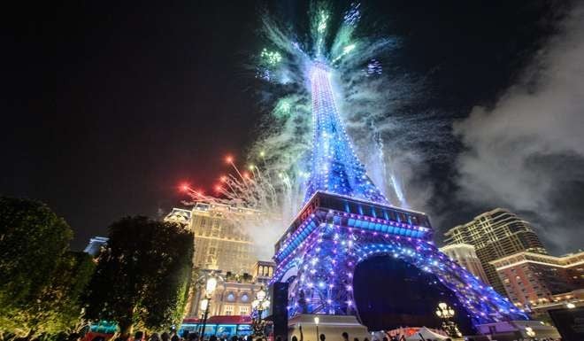 People gather to watch fireworks exploding from a replica of the Eiffel Tower after the opening of the Sands new mega resort The Parisian in Macau. Photo: AFP