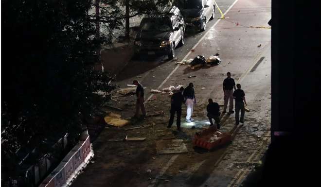 Police investigators look through the debris on the street in front of St Vincent de Paul church where the explosion occurred. Photo: EPA