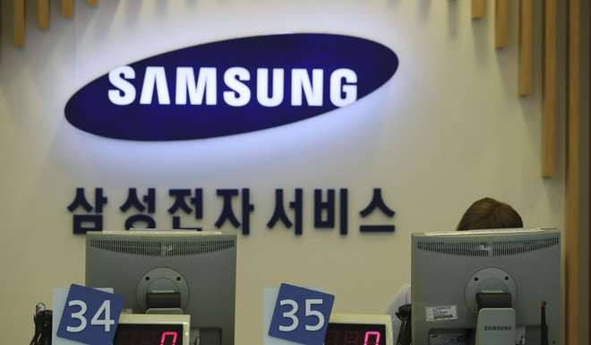 An employee sitting behind a computer monitor, waits for customers at Samsung Electronics' service centre in Seoul, South Korea,. Photo: AP