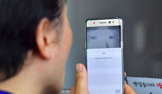 A South Korean man sets up iris recognition function on his replacement Samsung Galaxy Note 7 smartphone at a telecommunications shop in Seoul. Photo: AFP