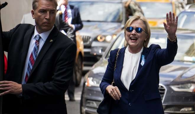 Hillary Clinton waves as she emerges from her daughter's apartment building in New York on September 11, after having to abruptly leave a 9/11 anniversary ceremony. Photo: AP