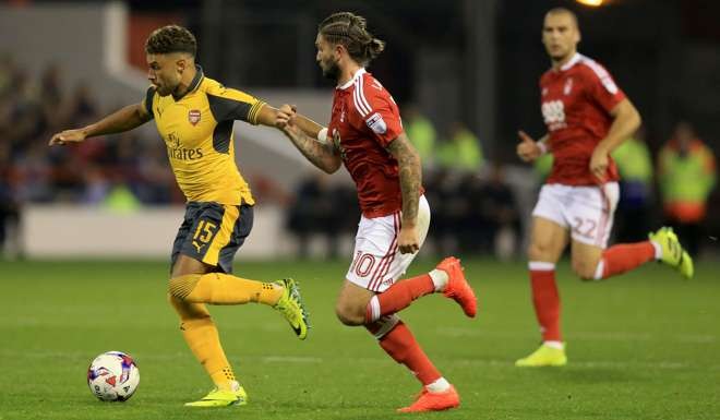 Arsenal's Alex Oxlade-Chamberlain and Nottingham Forest's Henri Lansbury battle for the ball. Photo: AP