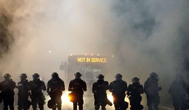 Police officers wearing riot gear block a road during the protests in Charlotte, North Carolina. Photo: Reuters