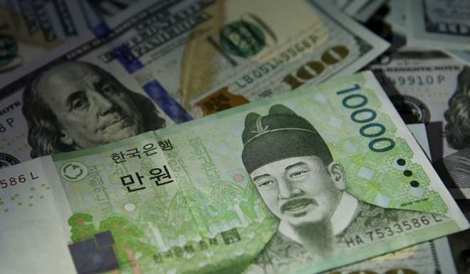 South Korean 10,000 won note is seen on US 100 dollar notes in this picture illustration taken in Seoul, South Korea. Photo: Reuters