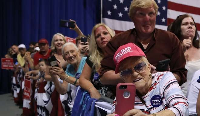 Supporters of Donald Trump listen to his speech in Aston, Pennsylvania. Many people are unware of the power of the affect heuristic, which leads us to favour quick fixes. Photo: AFP
