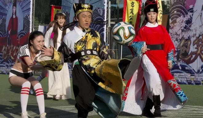 An actor wearing a costume depicting the legendary Justice Bao character popular in the Qing dynasty kicks a football during an event promoting an internet film in Beijing in July 2014. Photo: AP