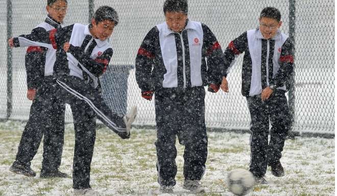 Pupils play soccer in the snow in Beijing in November 2009. Photo: Xinhua