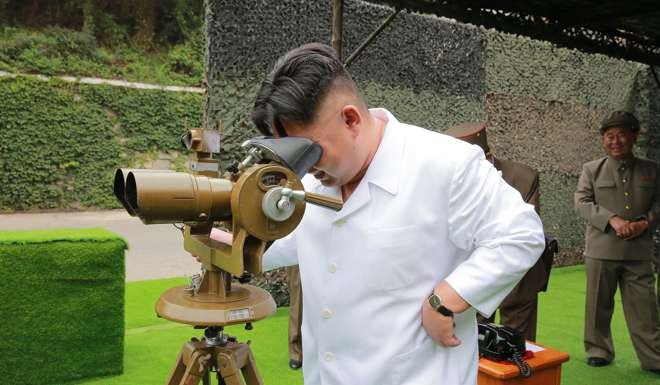 North Korean leader Kim Jong Un looking though binoculars at the site of a ballistic missile launching at an undisclosed location in North Korea. Photo: Korean Central News Agency/Korea News Service via AP