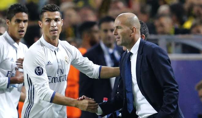 Real Madrid's Cristiano Ronaldo celebrates scoring the opening goal with Real Madrid's head coach Zinedine Zidane during the Champions League group F soccer match between Borussia Dortmund and Real Madrid in Dortmund, Germany, Tuesday, Sept. 27, 2016. (AP Photo/Michael Probst)