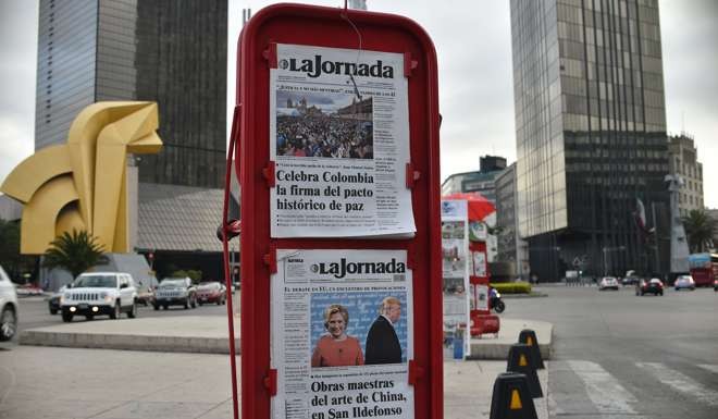 View of a newsstand displaying front pages showing images of US presidential candidates debate and Colombia's peace agreement, in Mexico City on September 27, 2016. Photo: AFO