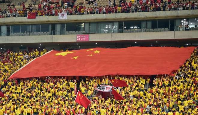 This file photo taken on September 1, 2016 shows Chinese fans carrying a huge national flag during the 2018 World Cup qualifying football match between South Korea and China in Seoul. AFP PHOTO / JUNG YEON-JE