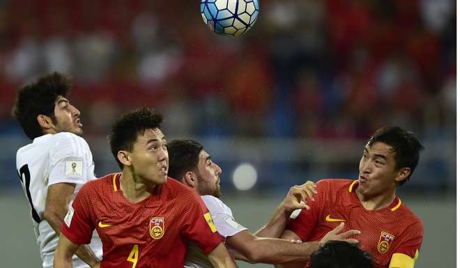 Iran's Mehdi Torabi, left, and Alireza Jahanbakhsh, third from left, fight for the ball against China's Li Xuepeng, second from left, and Feng Xiaoting, right, during the World Cup 2018 qualifying soccer match in Shenyang in northeast China's Liaoning province, Tuesday, Sept. 6, 2016. (Color China Photo via AP)