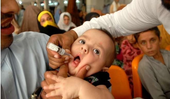 A Pakistani health worker administers vaccine drops to a child during an anti-polio campaign in Peshawar. Photo: Xinhua