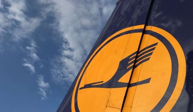 The Deutsche Lufthansa AG logo sits on the tail fin of a passenger jet as it sits on the tarmac at Frankfurt Airport. Photo: Bloomberg