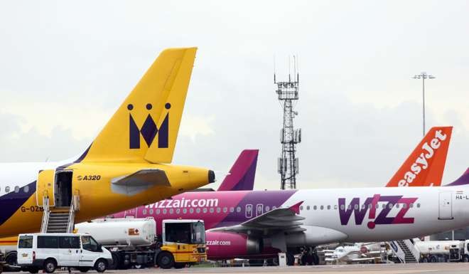 An Airbus SAS A320 passenger aircraft, operated by Monarch Airlines Ltd., sits next to passenger aircraft operated by Wizz Air Holdings Ltd. and easyJet Plc at London Luton Airport. Photo: Bloomberg