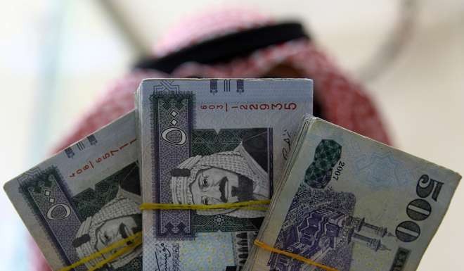 A Saudi money changer displays Saudi Riyal at a currency exchange shop in Riyadh, Saudi Arabia. Photo: Reuters