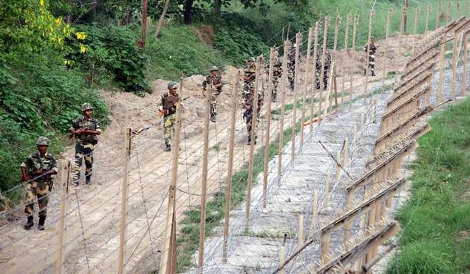 Indian Border Security Force soldiers patrol near the fence at the India-Pakistan International Border. Photo: EPA
