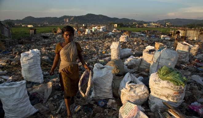 A girl collects recyclable material at a garbage dumping site on the outskirts of Gauhati, India. Photo: AP