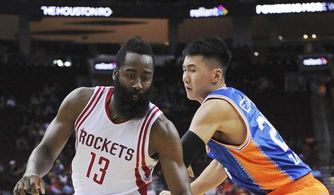 The Houston Rockets James Harden drives against the Shanghai Sharks Zhai Yi. Harden scored 16 points and handed out 10 assists.
