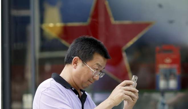 A man uses his mobile phone in Beijing. A popular blogger was recently censured by a court after mocking a Communist Party tale about a war hero. Photo: AP