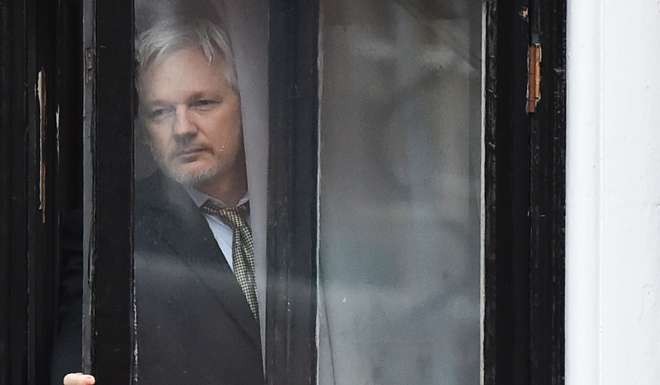 Assange comes out to the balcony of the Ecuadorian embassy to address the media in central London in February. File photo: AFP