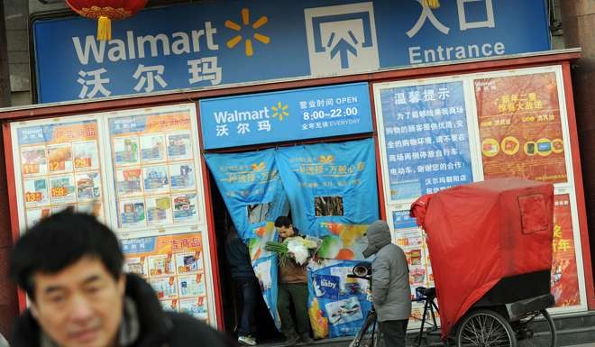 Chinese shoppers leave a Walmart store in Beijing. Wal-Mart will transfer its online Yihaodian operations in China to JD.com in exchange for a stake in the Chinese e-commerce giant. Photo: AFP