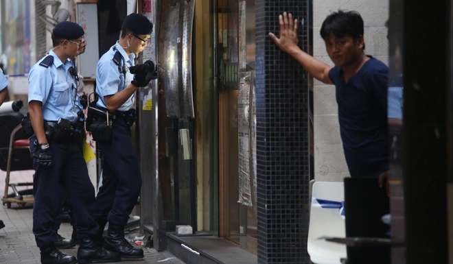 Police conduct door-to-door enquiries in their hunt for suspects after the shooting in Yau Ma Tei. Photo: Sam Tsang