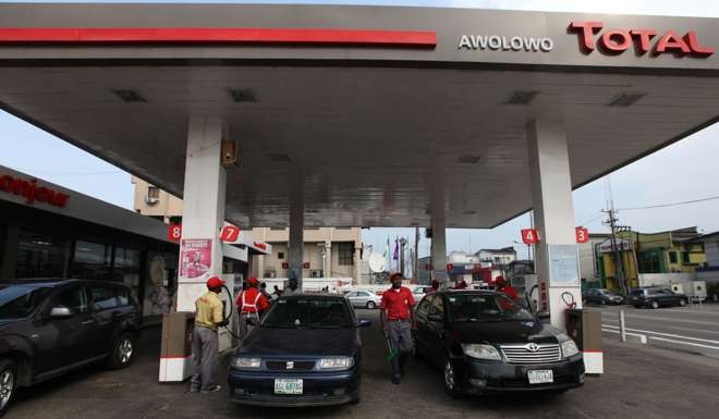 Petrol attendants fill cars at a Total petrol station in Lagos, Nigeria. Photo: AP