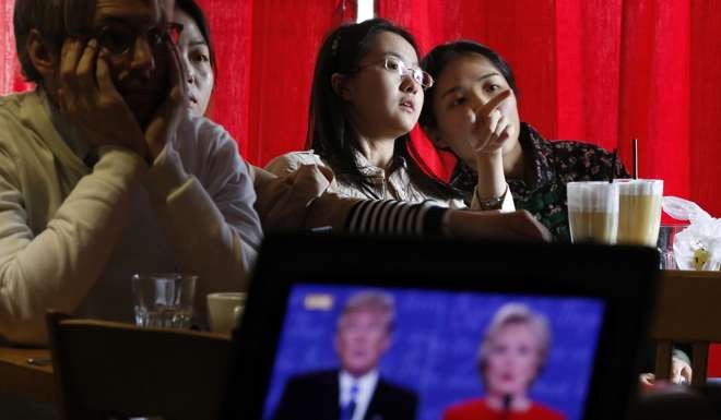 Students in a cafe in Beijing watch a live broadcast of last month’s presidential debate between Hillary Clinton and Donald Trump. Photo: AP