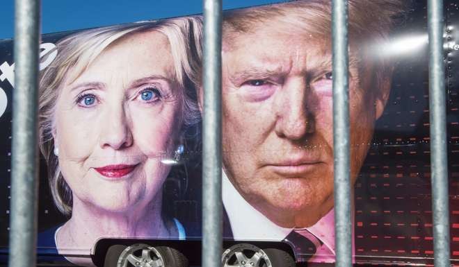 Images of Democratic nominee Hillary Clinton and her Republican rival Donald Trump on a CNN vehicle, seen from outside a security fence. Photo: AFP