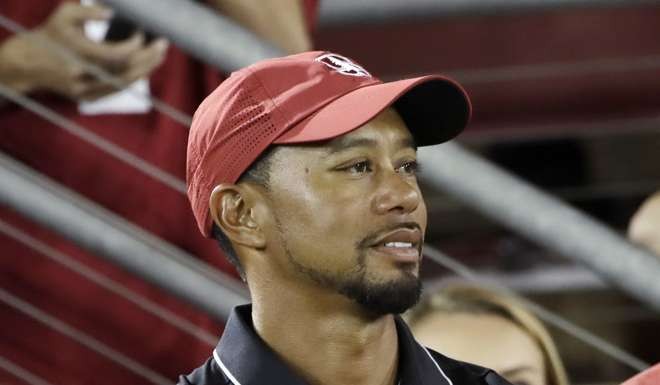 Golfer Tiger Woods, left, watches an NCAA college football game between Stanford and Washington State, in Stanford, California. Photo: AP