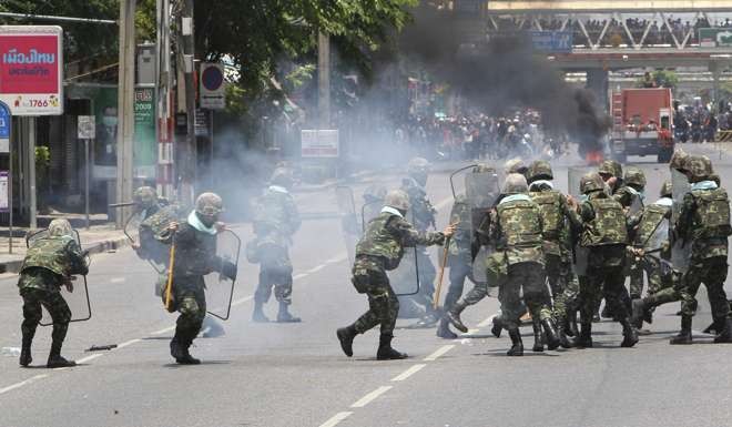 Thai army troops scramble as a tear gas grenade is thrown back at them during clashes with anti government protesters in Bangkok in 2010. File photo: EPA