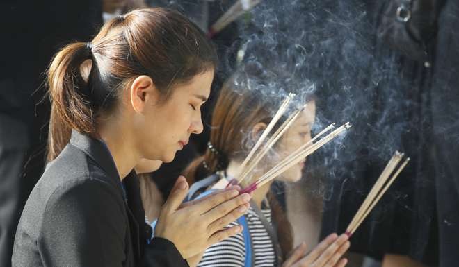 Mourners pray while waiting to offer condolences to late Thai King Bumibol Adulydej at Siriraj Hospital in Bangkok. Photo: AP