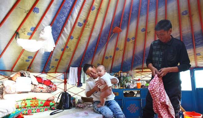 Narentuya, her husband and their infant son in their yurt in New Barag Left Banner. Photo: Simon Song